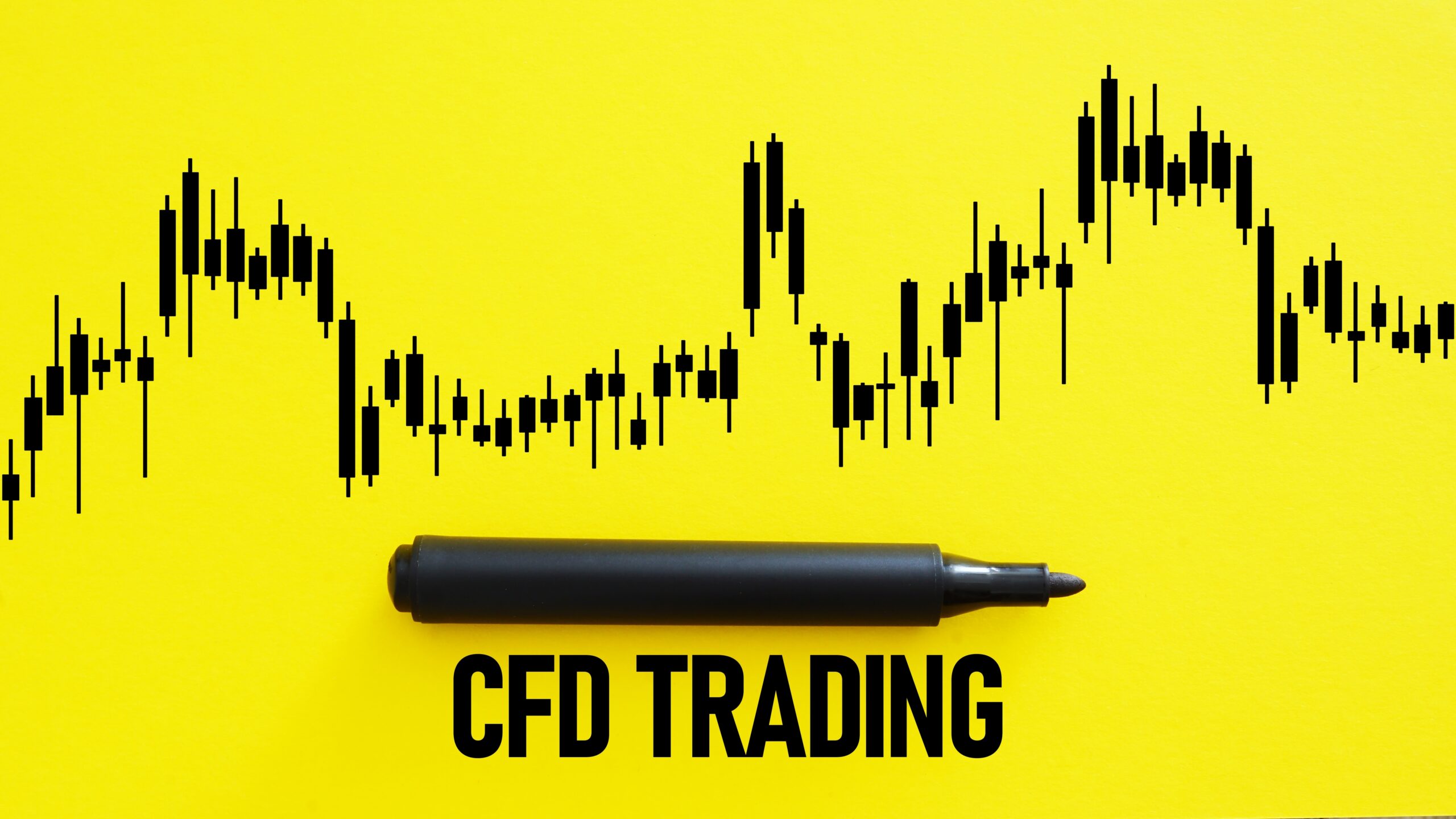 A black marker rests horizontally below the bold, black text "CFD TRADING" on a vibrant yellow background. Above the marker and text, a black candlestick chart displays price fluctuations over time, suggesting the dynamic nature of contract for difference trading.